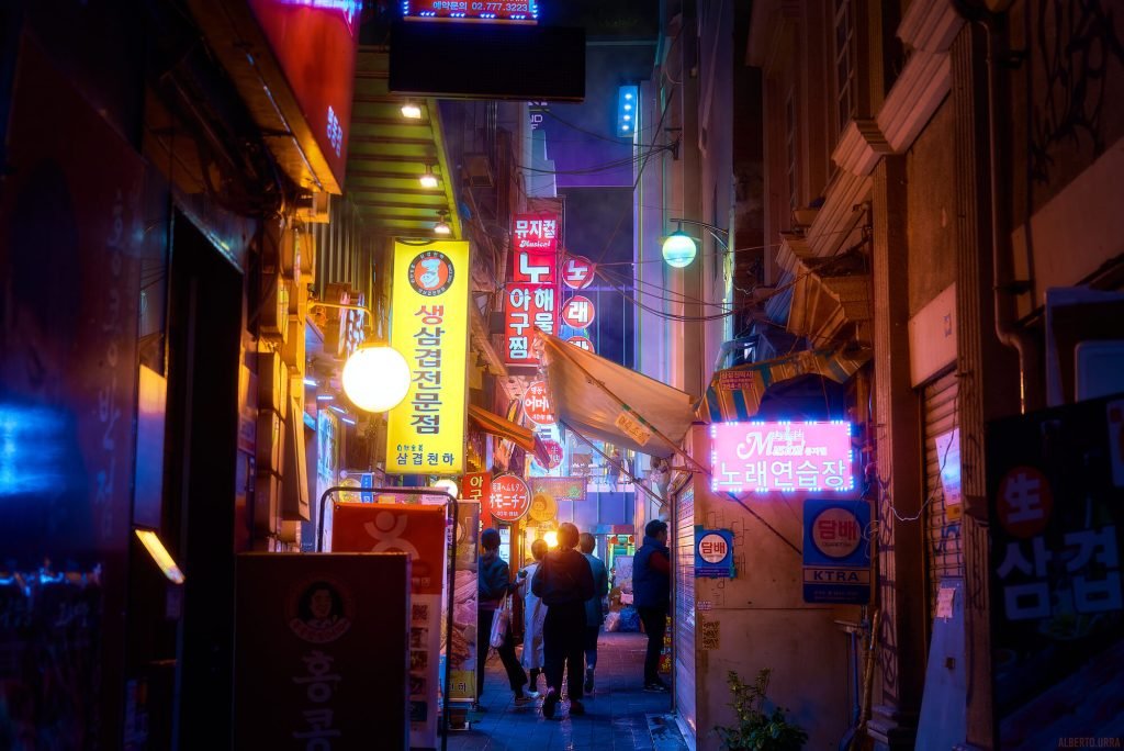 Fotografía Cyberpunk de un callejón colorido en Seúl con la silueta de varias personas